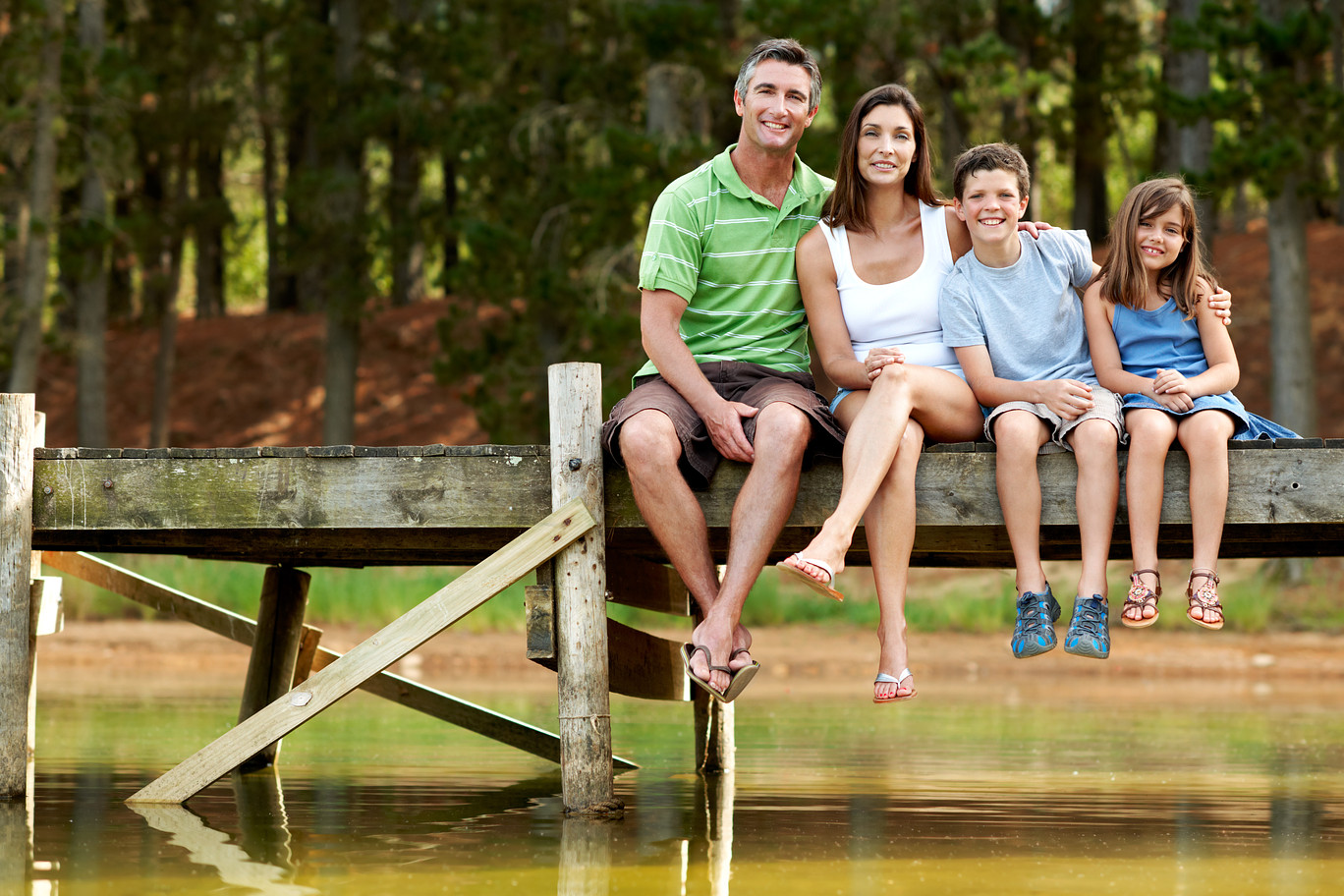 image family sitting on a dock on a lake